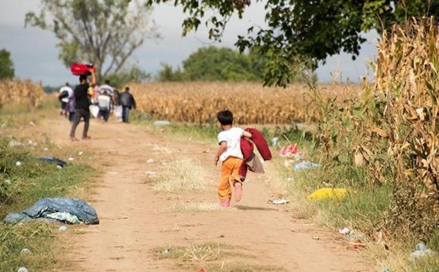 Dječak trči da sustigne grupu izbjeglica: Naslovna fotografija izložbe 'Udaljeni horizont' 