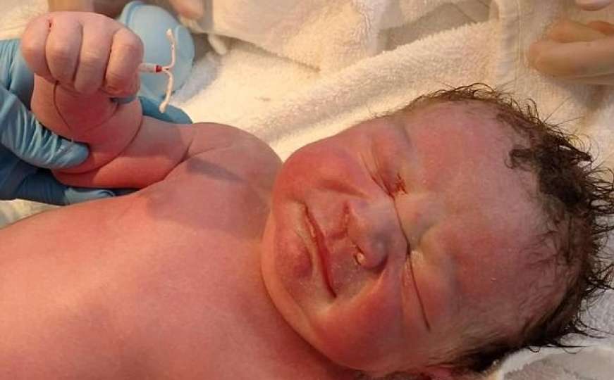 Novorođenče u ruci čvrsto drži maminu spiralu protiv začeća