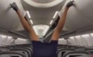 Akrobacije u avionu: Stjuardesa nogama zatvara pretince za ručni prtljag