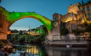 Foto: Mostarski.ba / Cvijet Srebrenice u četvrtak navečer je osvijetljen na Starom mostu u Mostaru