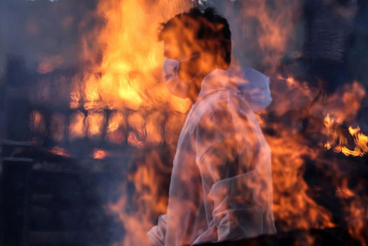 Foto: EPA-EFE/Radnik pored pogrebnih vatri u Indiji