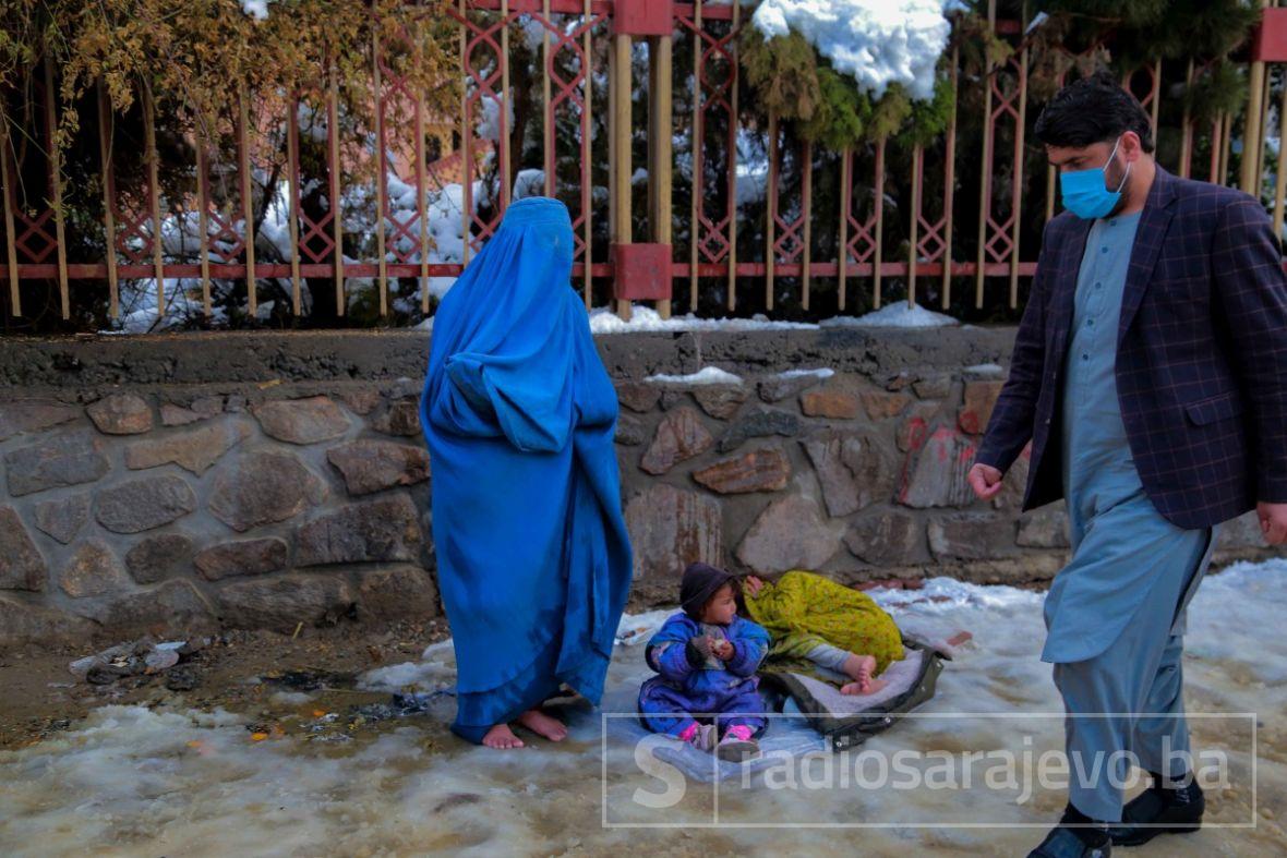 Afganistanska žena moli za milostinju, bosa na snijegu u Kabulu.  - undefined