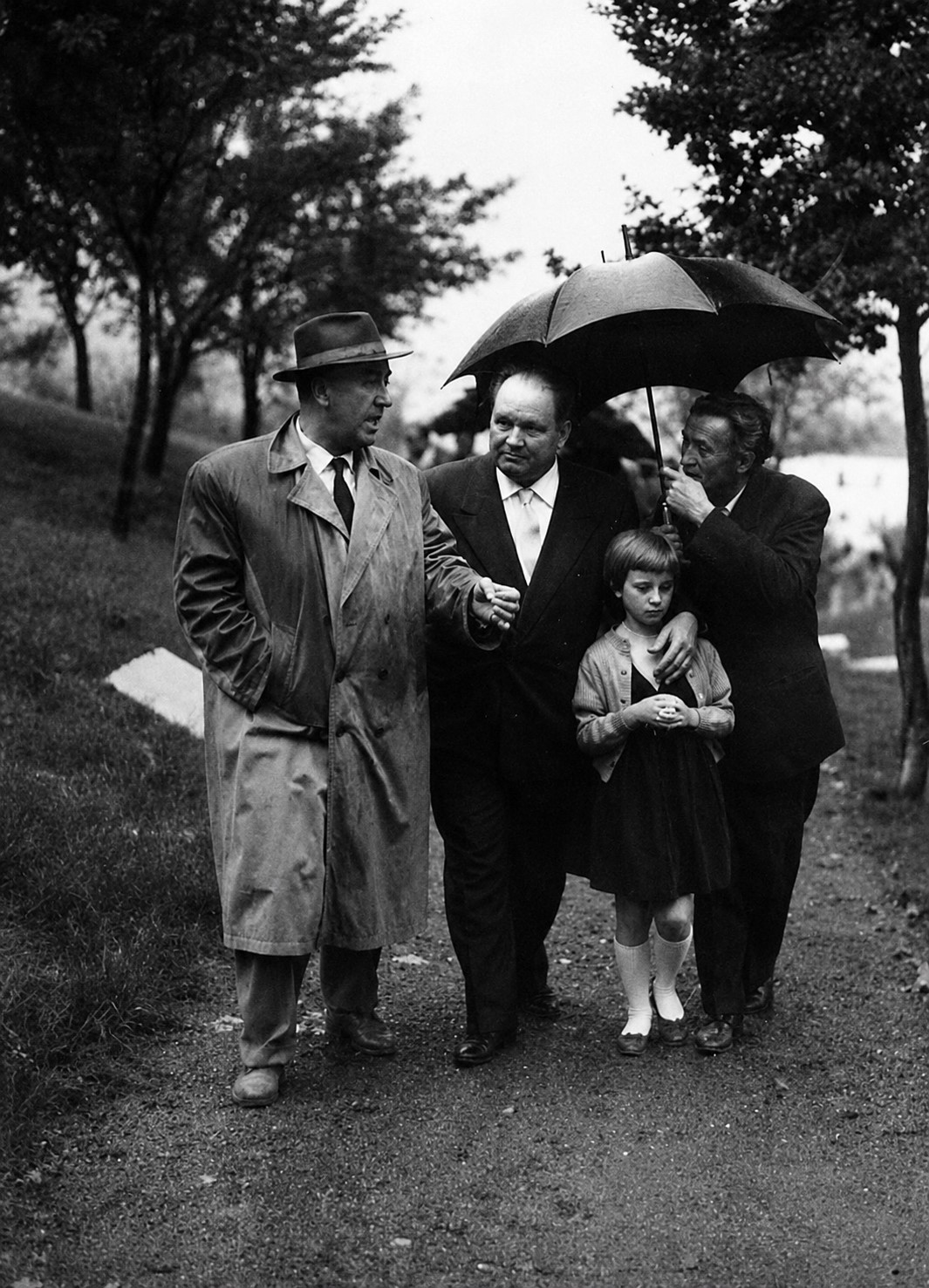 Pašaga Mandžić pod Mujezinovićevim kišobranom. S lijeva je Džemal Bijedić. Tuzla, 1962